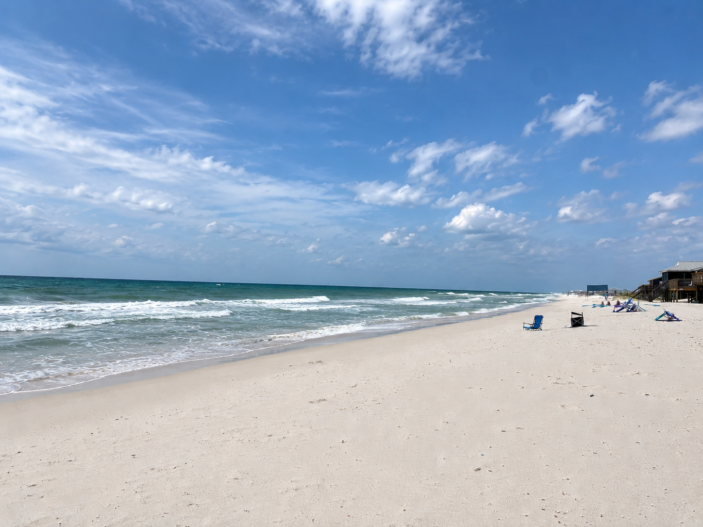Wide view of the quiet white-sand beach and Gulf near Good Tides Only